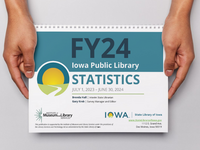 Hands holding a print copy of the Public Library Annual Statistics publication.
